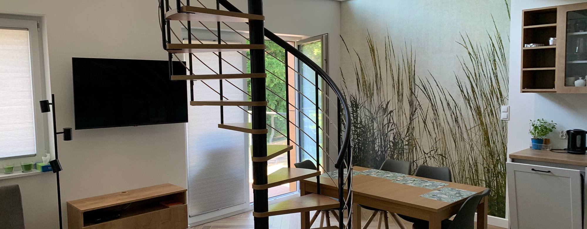 Montreal Spiral Staircase with wooden treads in an open-plan dining and living area.