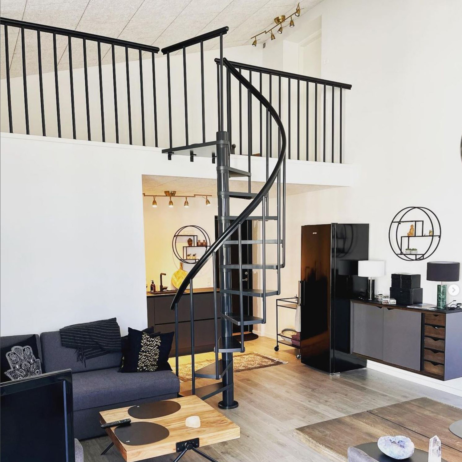 Black Spiral staircase in living room provides access upstairs