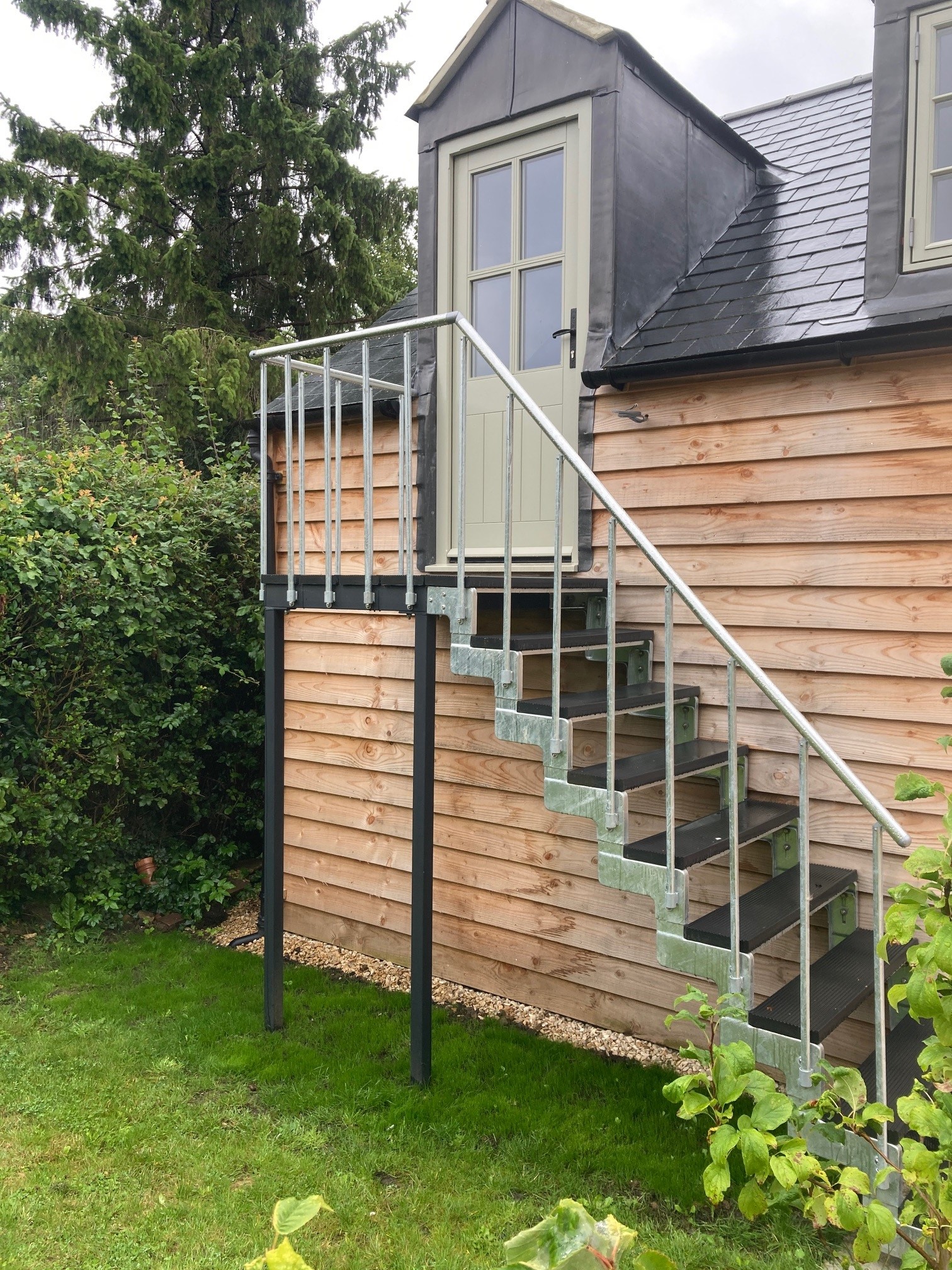 outdoor staircase attached to an existing timber platform by cottage