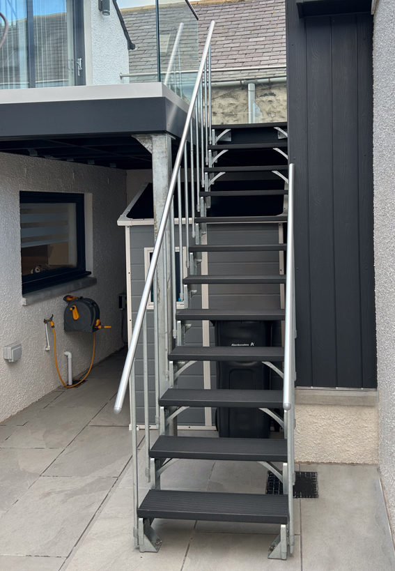 Outdoor long stair going from patio down into back garden  